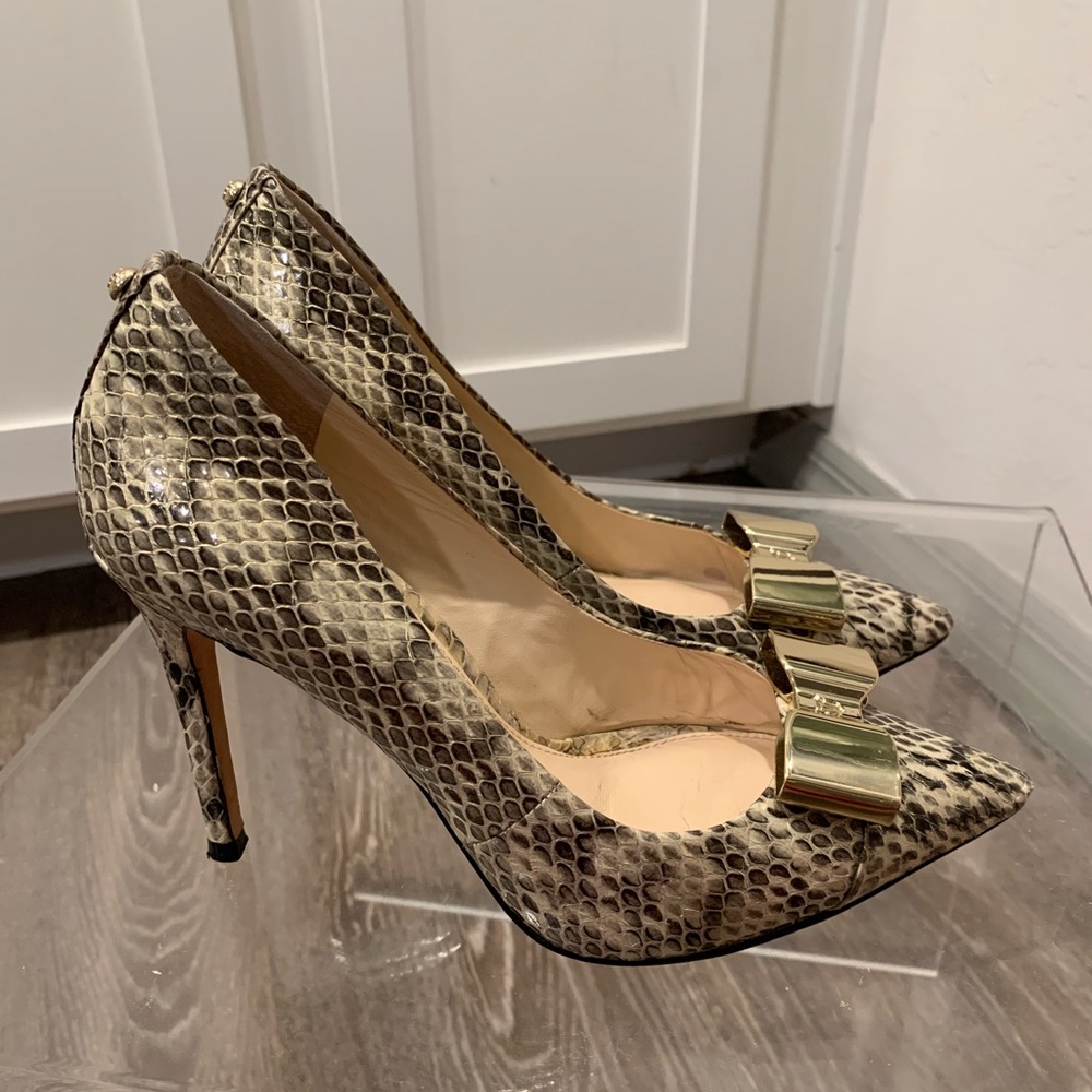 Vince Camuto snake pumps with gold bow detail.